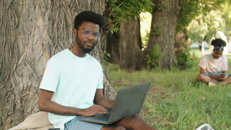 Porträt-Eines-Jungen-Afroamerikanischen-Mannes-Mit-Laptop-Im-Park